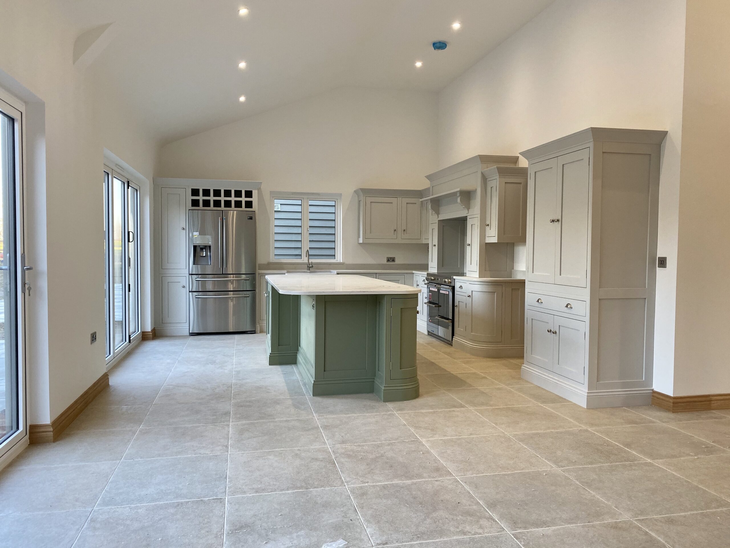 Modern bespoke kitchen with central island designed by a professional kitchen designer.