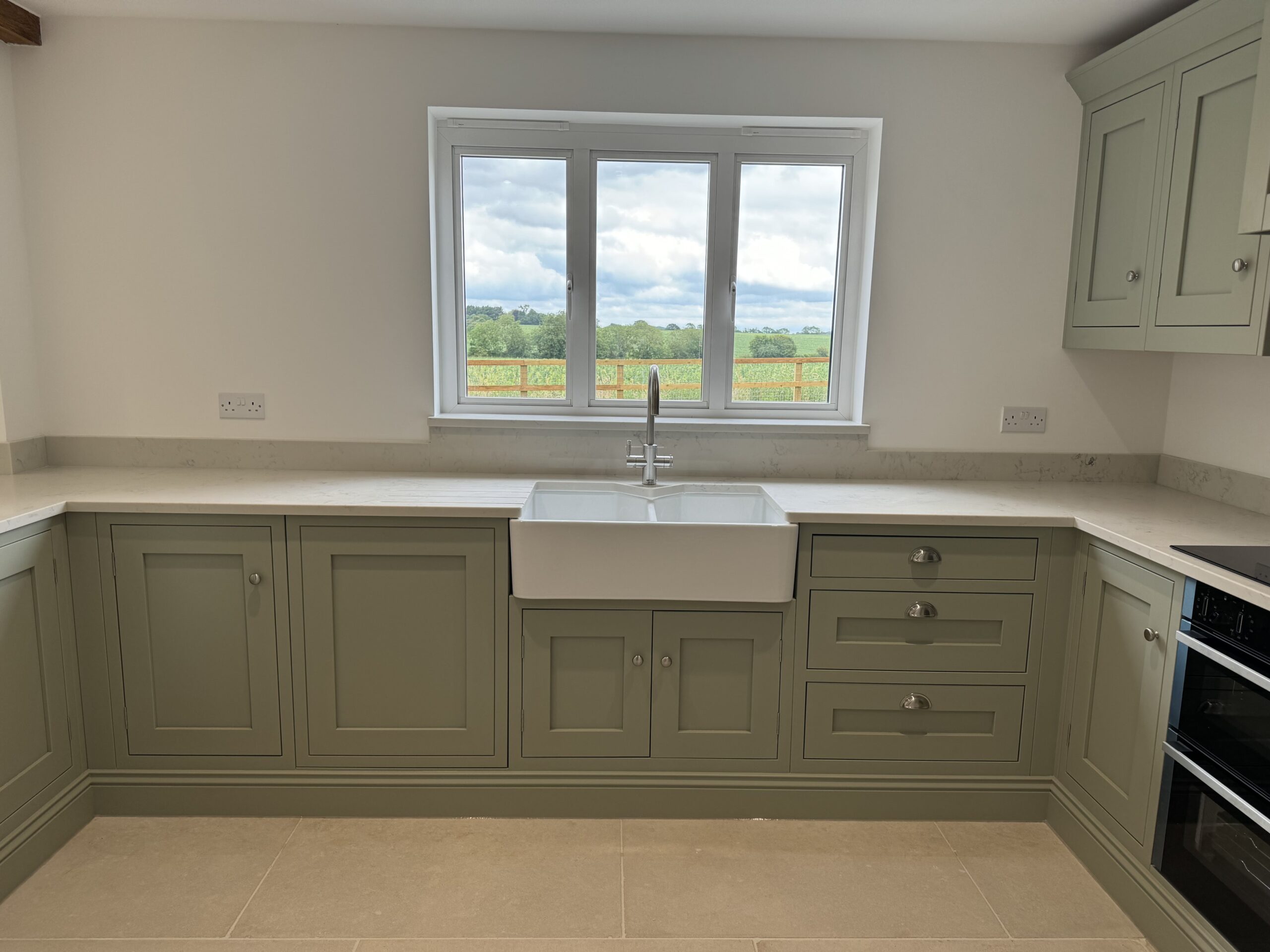 Luxury open-plan fitted kitchen in Essex featuring natural wood and heritage colour finishes.