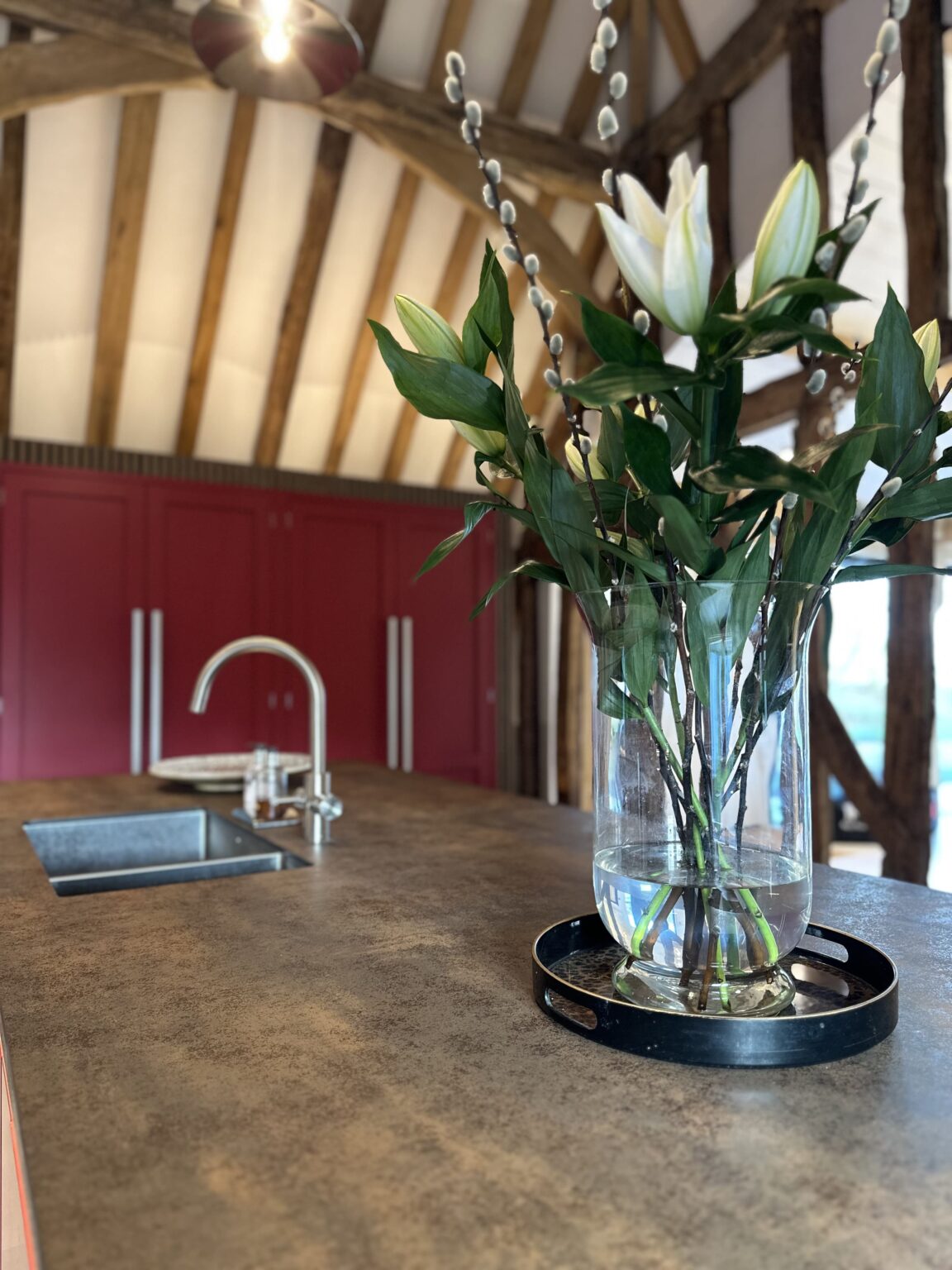 Modern barn conversion kitchen in Thaxted blending craftsmanship, layered textures, and warm lighting.