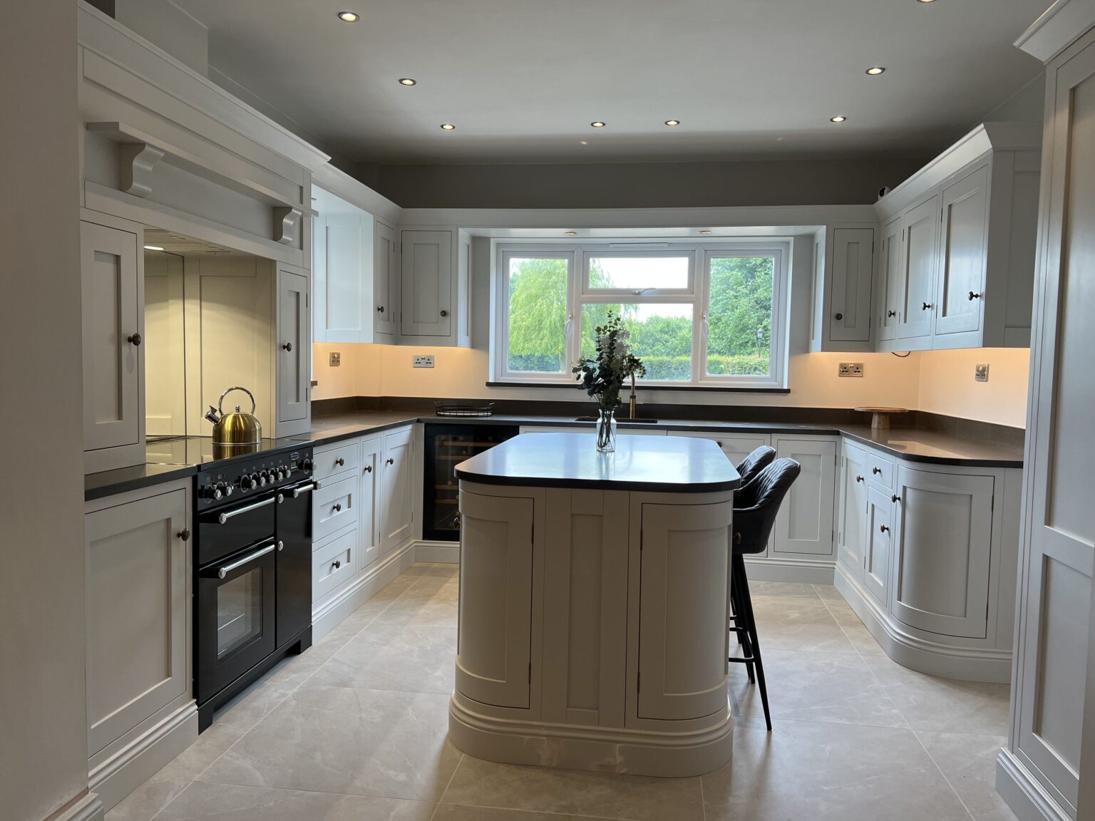 Curved bespoke kitchen island creating seamless flow between adjoining rooms in Sible Hedingham