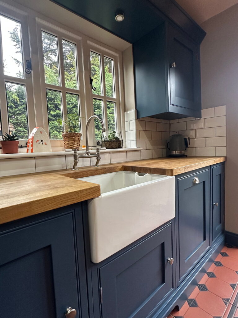 Bespoke kitchen in Gosfield with Belfast sink, navy cabinets, and oak worktops.
