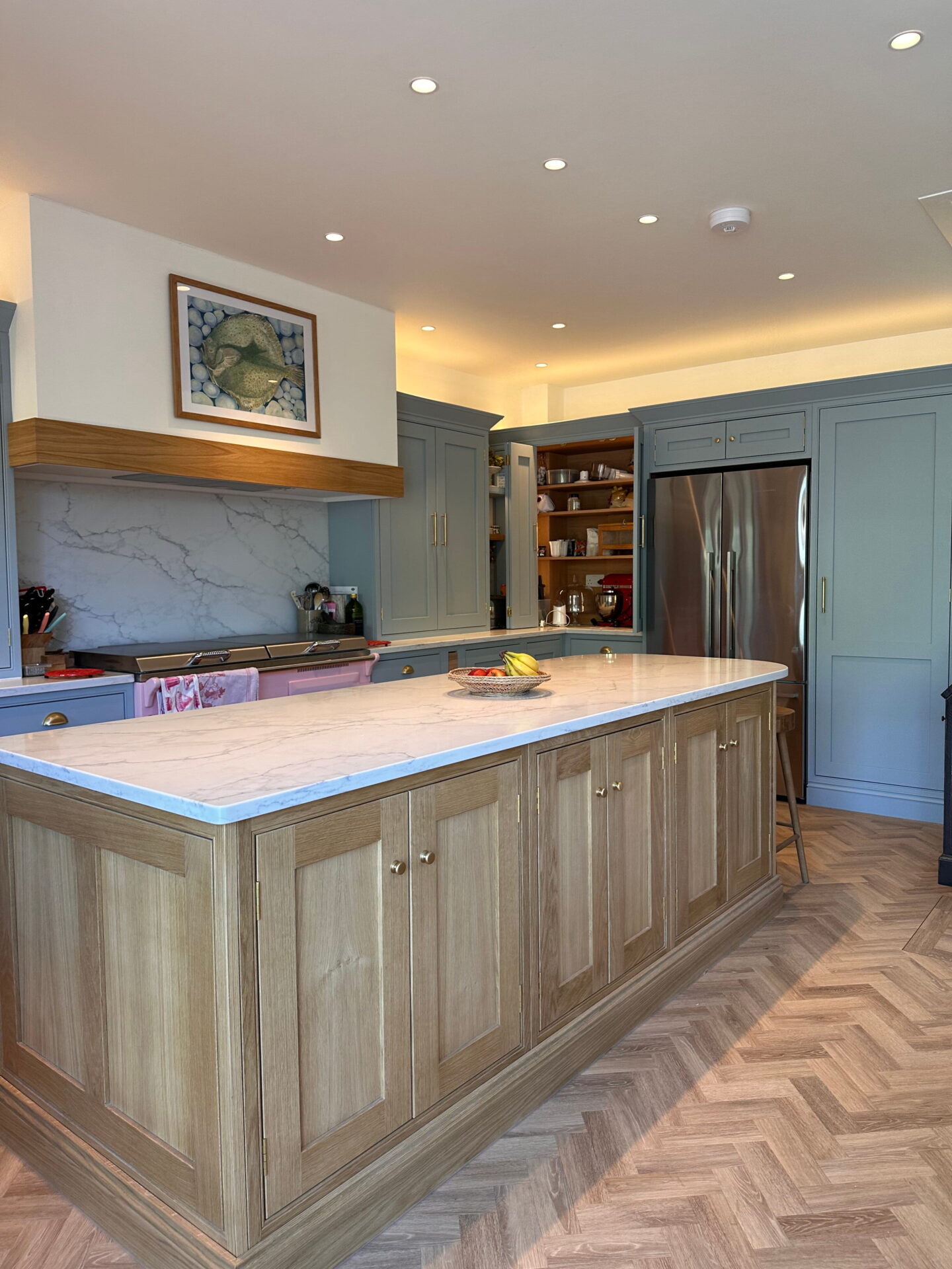 Bespoke Kitchen in Saffron Walden with oak island, shaker cabinets, and herringbone flooring.