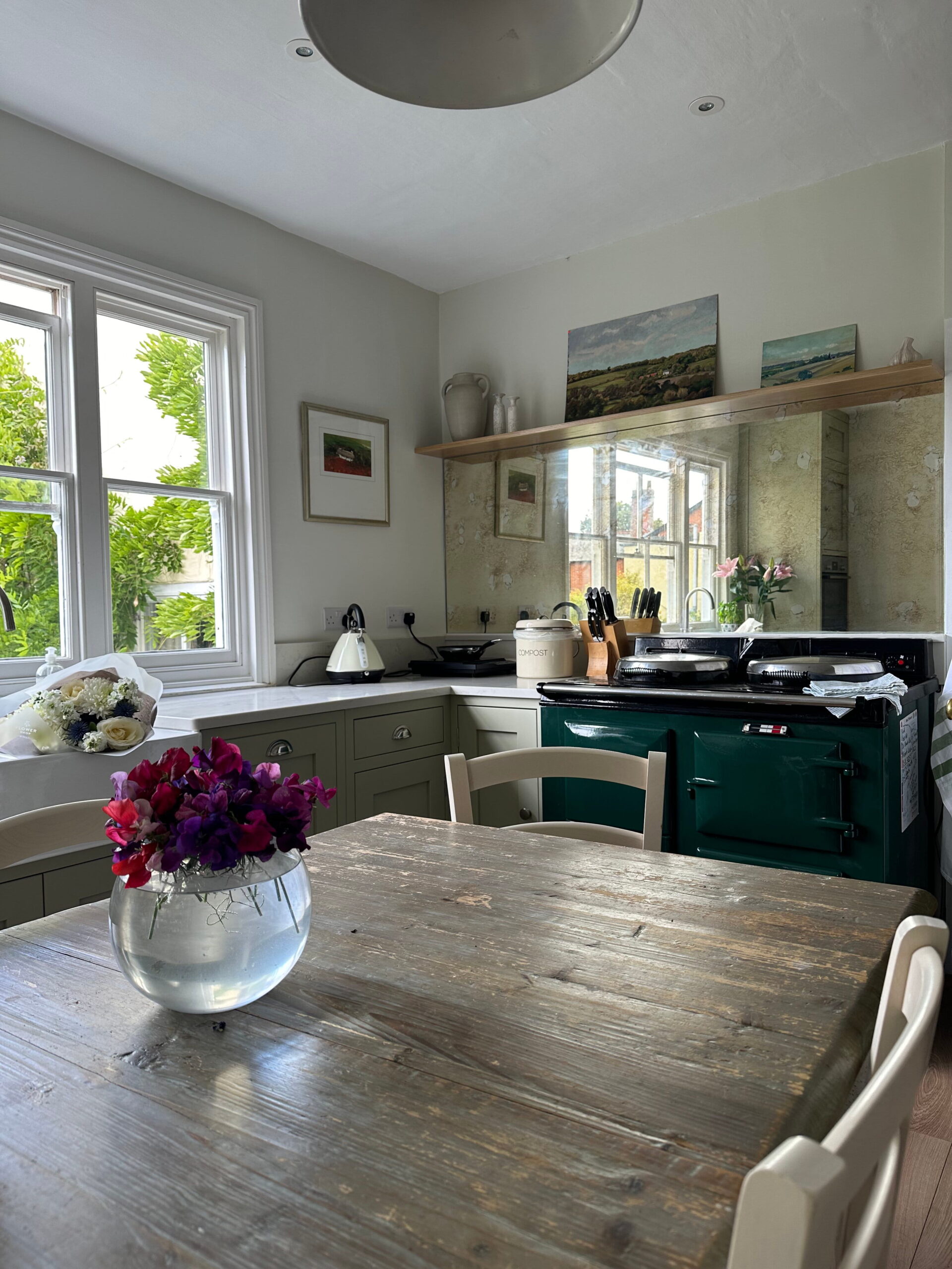 Bespoke kitchens finance for a cosy country-style kitchen with green cabinetry and rustic dining table.