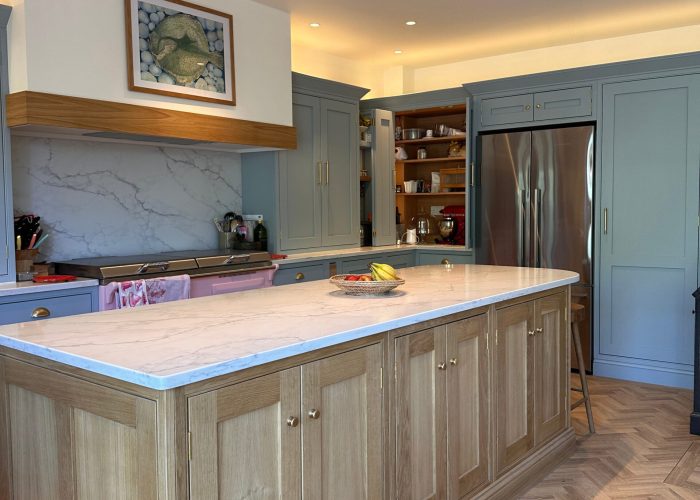 Bespoke Kitchen in Saffron Walden with oak island, shaker cabinets, and herringbone flooring.