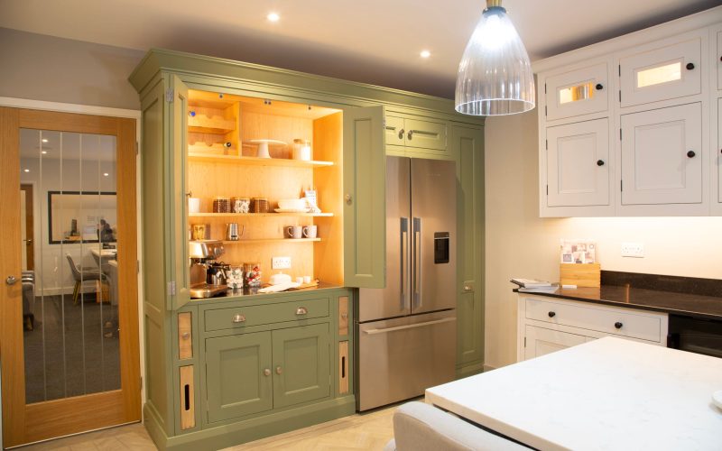 Made to measure kitchens by Regent St James Kitchens showing large kitchen showroom in Sage green finish and well lit pantry